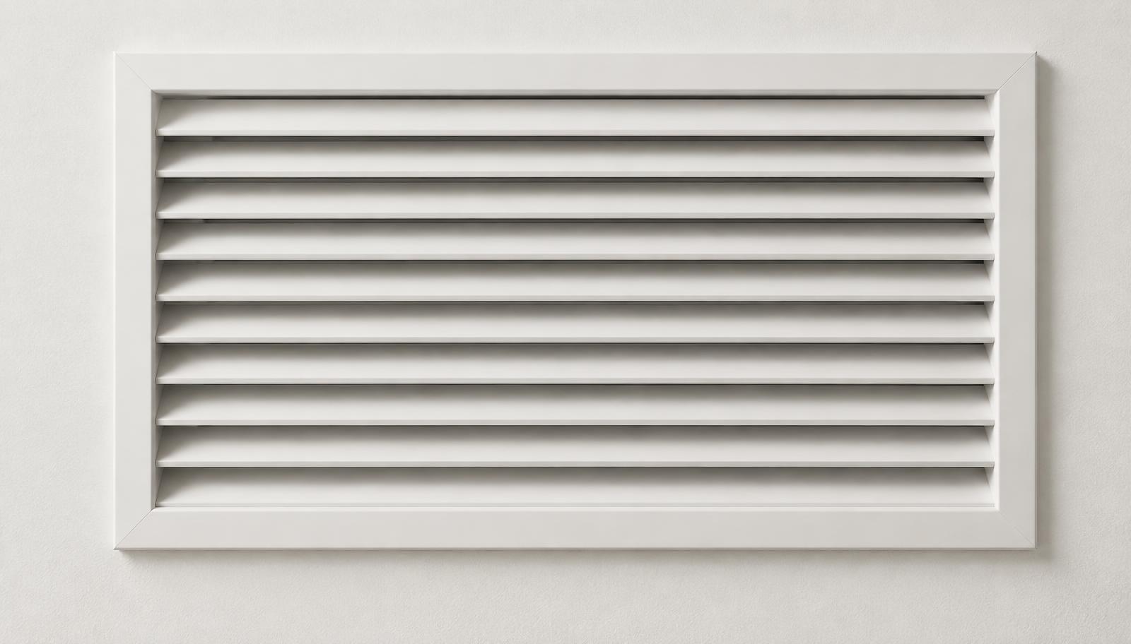 Détail d'une grille de ventilation sur un mur clair
